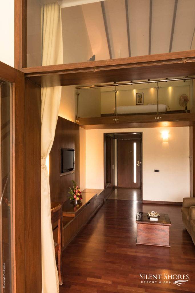 bright wooden duplex room hall with TV on the wall - best hotel rooms & resorts in Mysore